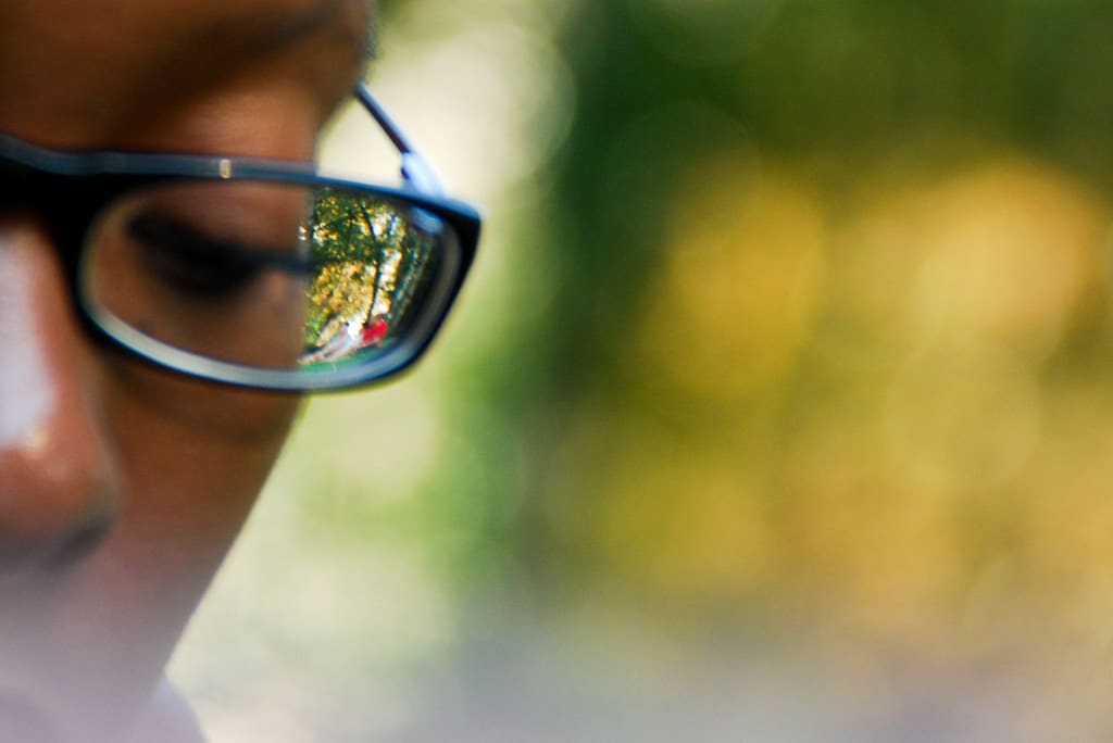 Personne avec des lunettes devant un fond flou